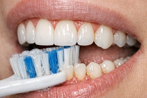 Person flossing between teeth carefully