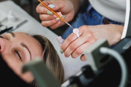 Dentist applying bonding resin to tooth